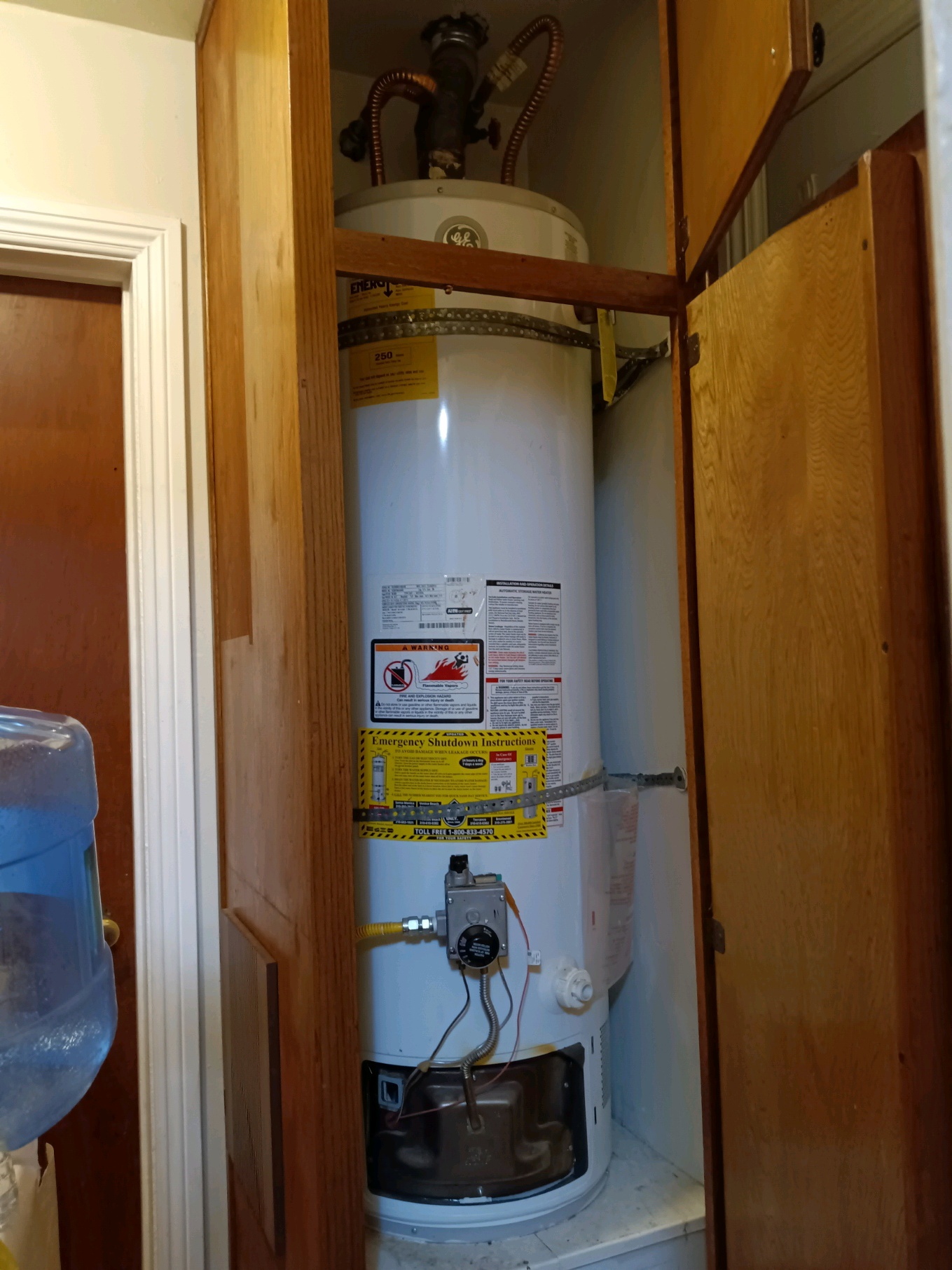 Gas water heater installed and strapped inside an indoor closet
