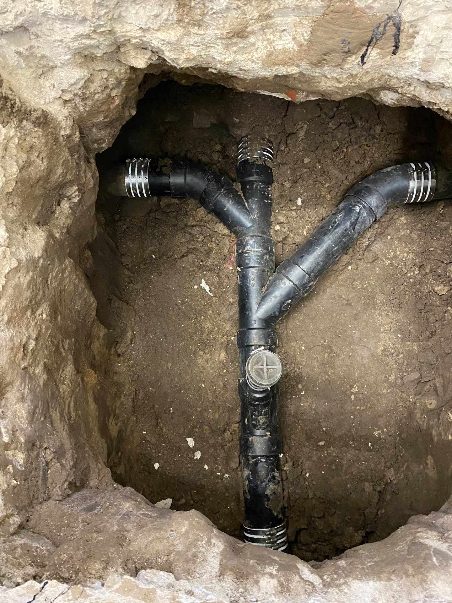 New ABS sewer wye and cleanout installed in an excavated trench